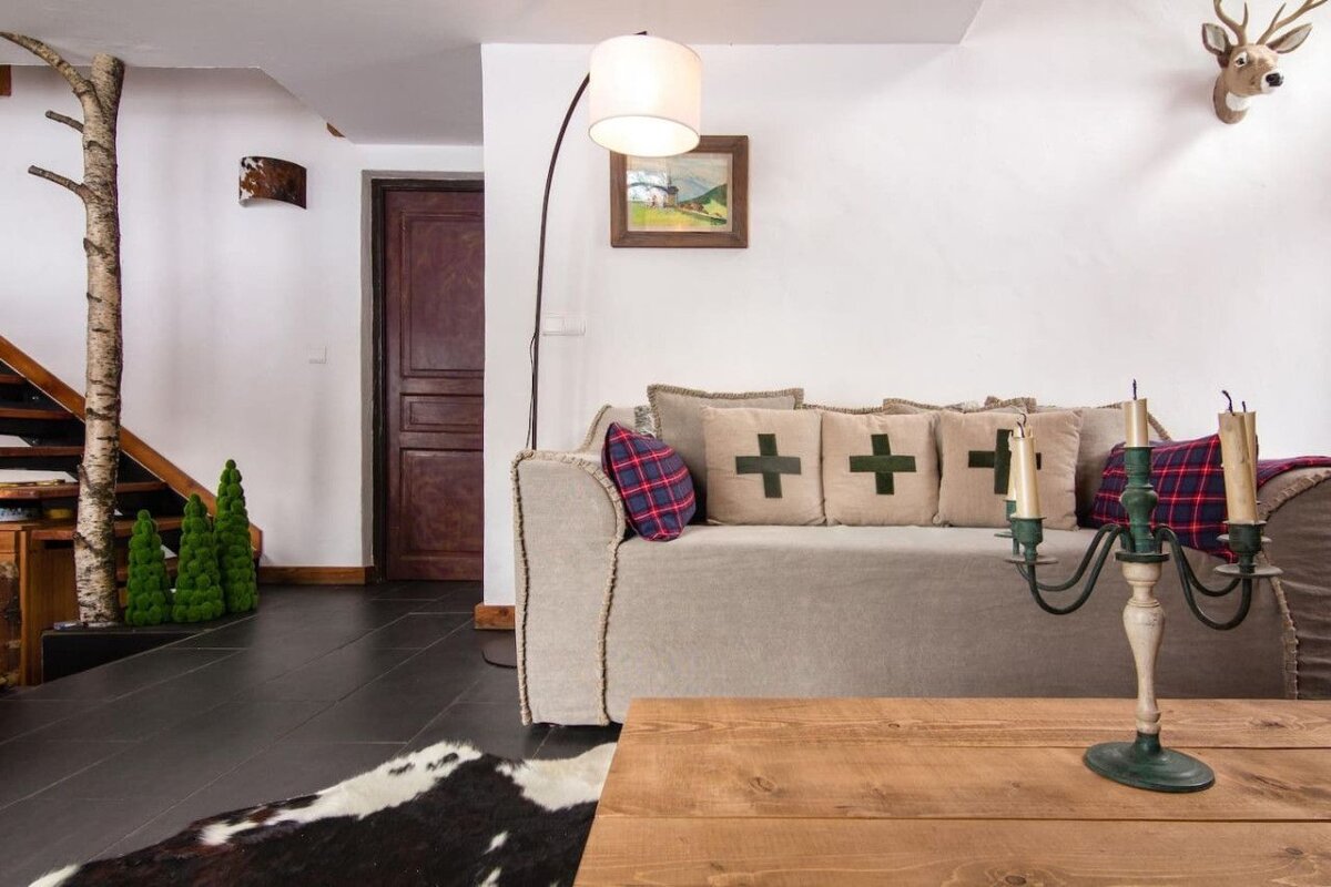A living room with a couch and pillows with green crosses on them