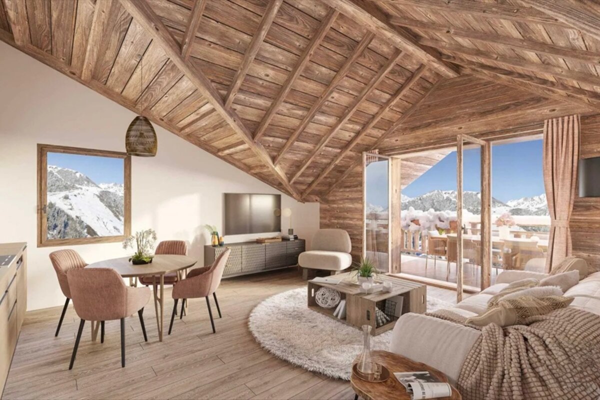 Cozy chalet living room with vaulted wood ceilings and large glass doors looking out onto snowy mountains.