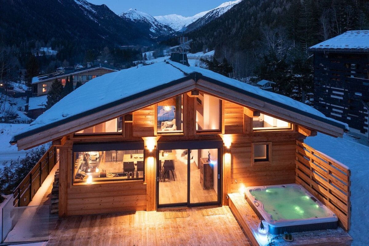A wooden house with a hot tub in front of it
