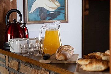 A pitcher of orange juice sits on a wooden counter