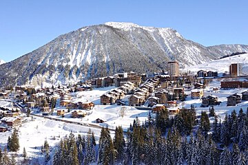 A snowy landscape with a mountain in the background