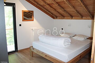 A bedroom with a bed and the number 80 on the wall