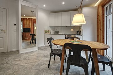 A kitchen with a table and chairs and a mirror