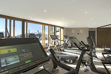 A gym with treadmills and a screen that says ' routines ' on it