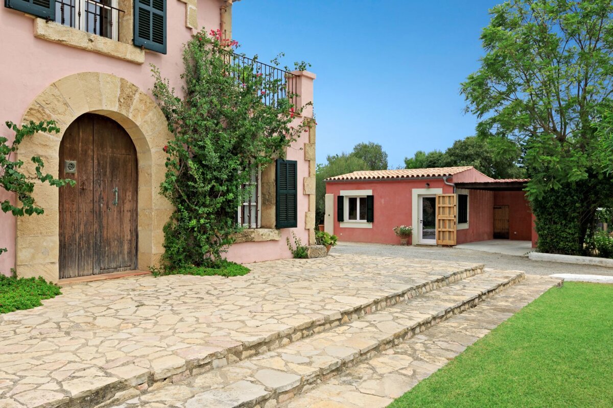 A pink house with a stone walkway leading up to it
