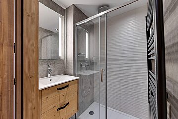 A bathroom with a sink and a walk in shower