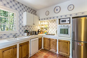 A kitchen with wooden cabinets and a stainless steel refrigerator