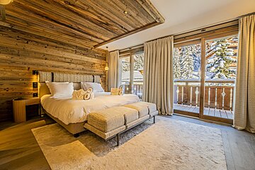 A bedroom with a bed and a bench with the letter s on it