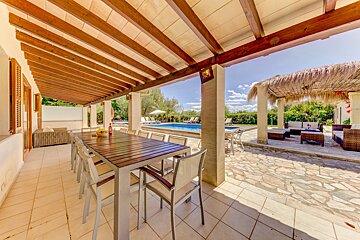 A patio with a table and chairs and a gazebo in the background