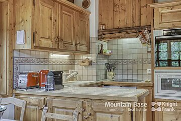 A kitchen with wooden cabinets and a knight frank logo