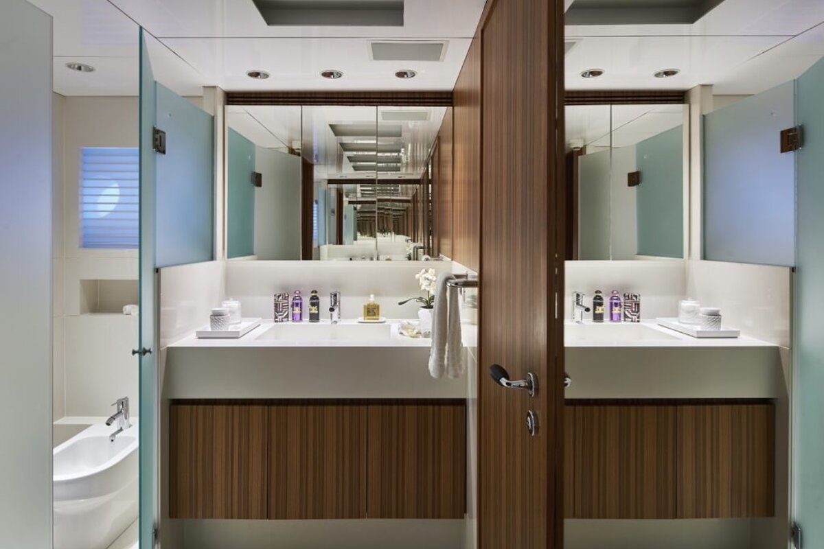 A bathroom with two sinks and two mirrors including one that says ritz