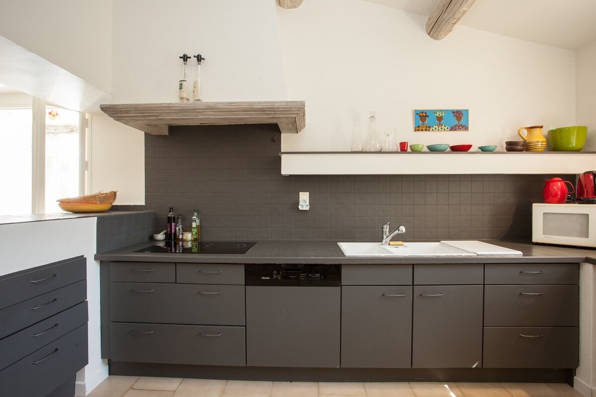 A kitchen with a stove top oven and a sink