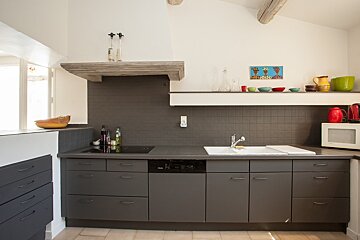 A kitchen with a stove top oven and a sink