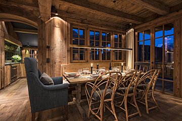A dining room with a wooden table and chairs