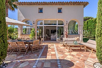 A patio with a table and chairs in front of a house that says j.d. janssen