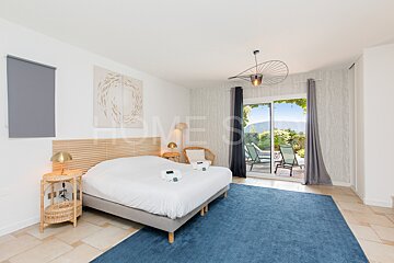 A bedroom with a large bed and a blue rug and the word home on the wall