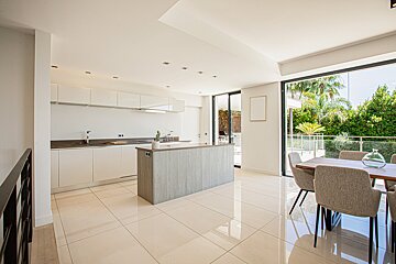 A kitchen with white cabinets and a large island