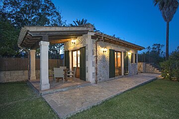 A small house with a patio and a table and chairs