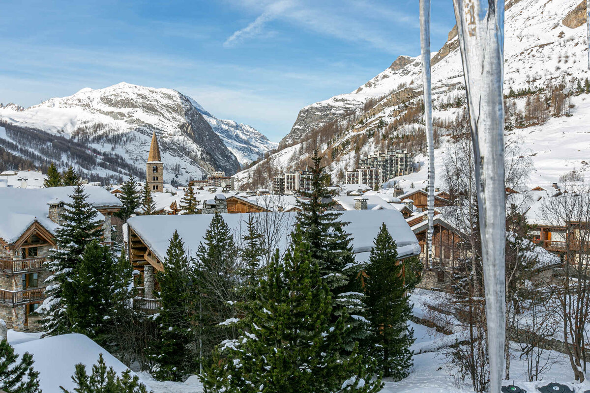 A snowy mountain village with a church in the background