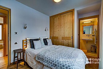 A bedroom with a bed and a sign that says mountain base knight frank