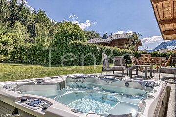 A hot tub in a backyard with a house in the background