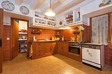 A kitchen with wooden cabinets and a white dishwasher