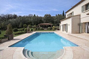 A large house with a large swimming pool in front of it