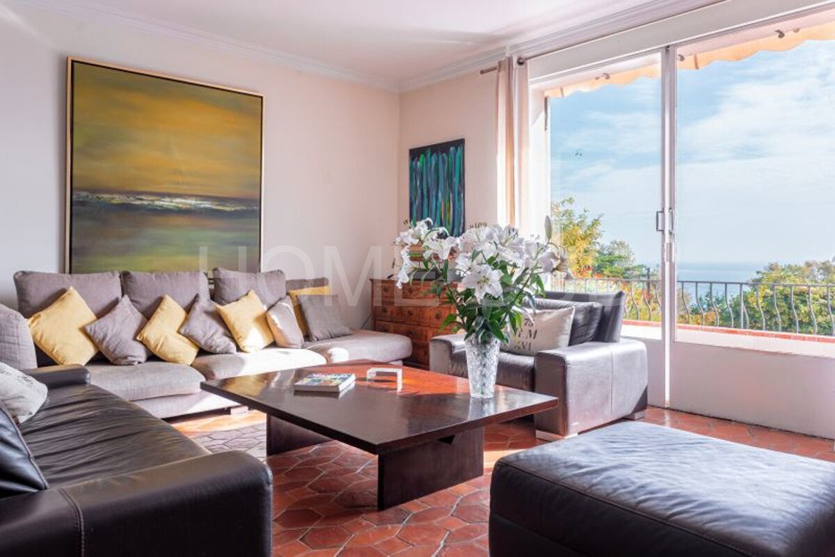 A living room with a couch and a coffee table with a vase of flowers on it