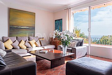 A living room with a couch and a coffee table with a vase of flowers on it