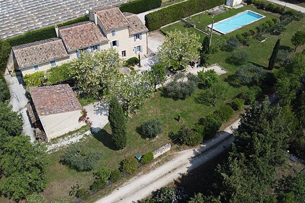 An aerial view of a house with a pool in the backyard