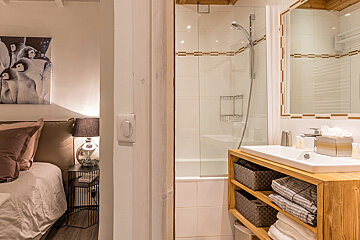 A bathroom with a sink and a picture of penguins on the wall