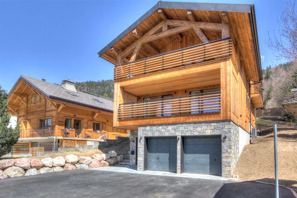 A large wooden house with a black garage door