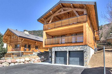A large wooden house with a black garage door
