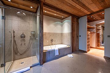 A bathroom with a bathtub and a walk in closet