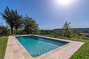 A large swimming pool surrounded by trees and grass