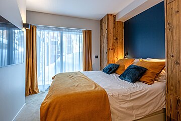 A bedroom with a large bed and a blue wall