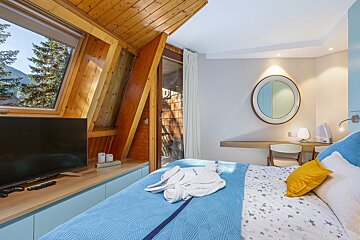 A bedroom with a large bed and a flat screen tv