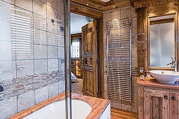 A bathroom with a tub a sink and a mirror