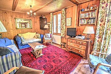 A living room with a blue couch and a red rug