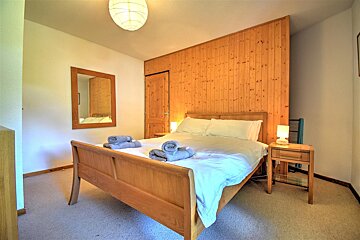 A bedroom with a bed and a mirror on the wall