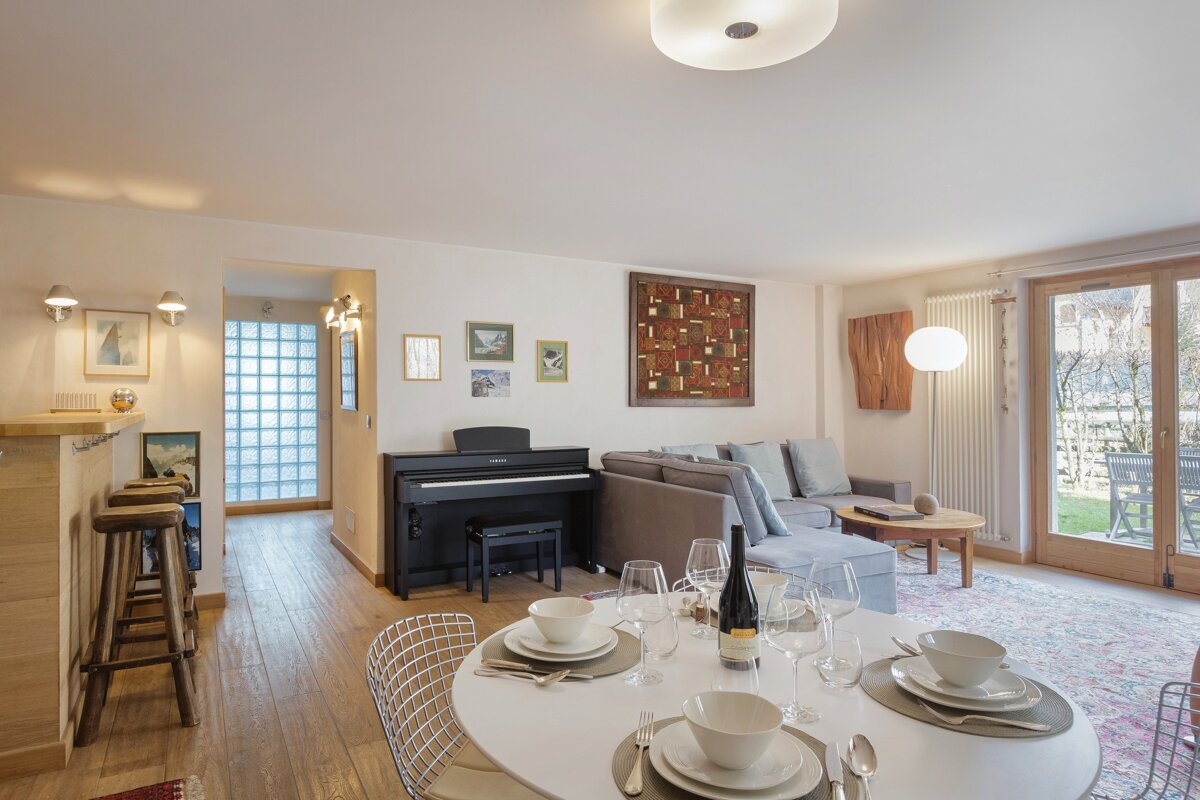 A living room with a piano and a dining table