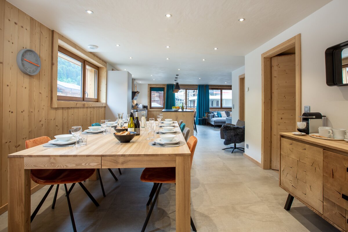 A dining room with a wooden table and orange chairs