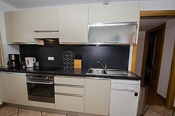 A kitchen with white cabinets and a bosch dishwasher