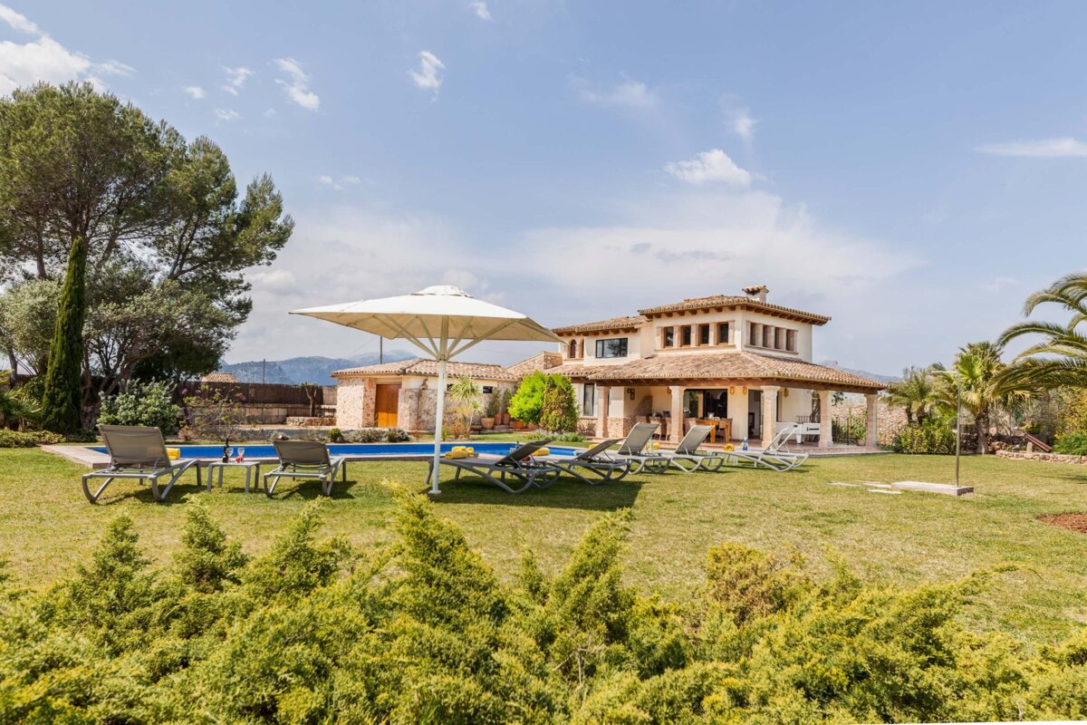 A large house with a swimming pool in front of it