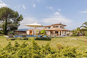 A large house with a swimming pool in front of it