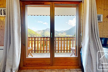 A balcony with a view of the mountains and a sign that says alpine-pr