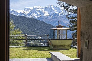 A view of the mountains from a balcony with a gondola in the foreground