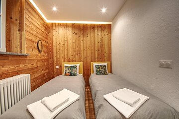 A bedroom with two twin beds and a radiator