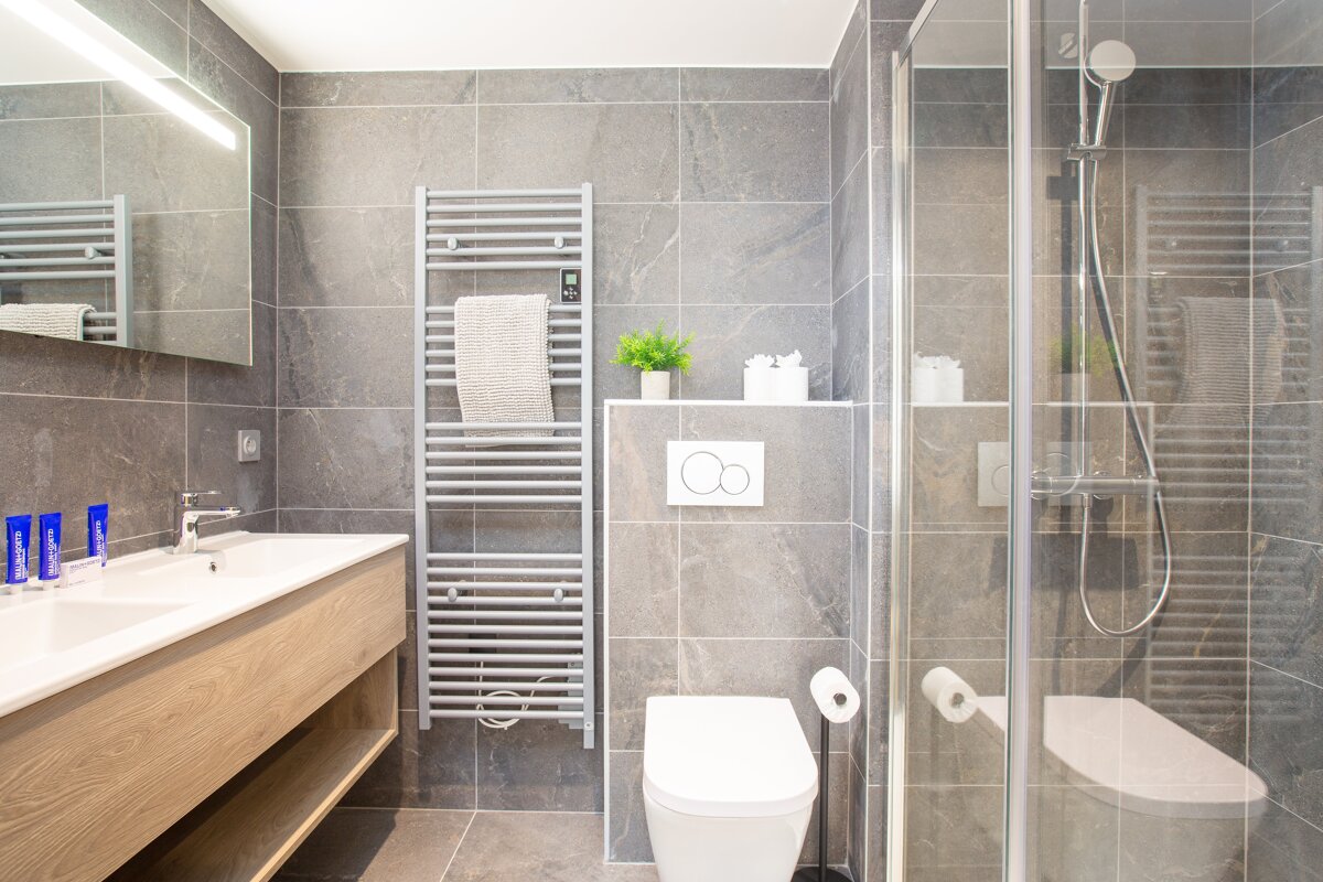 A bathroom with a toilet a sink and a towel rack