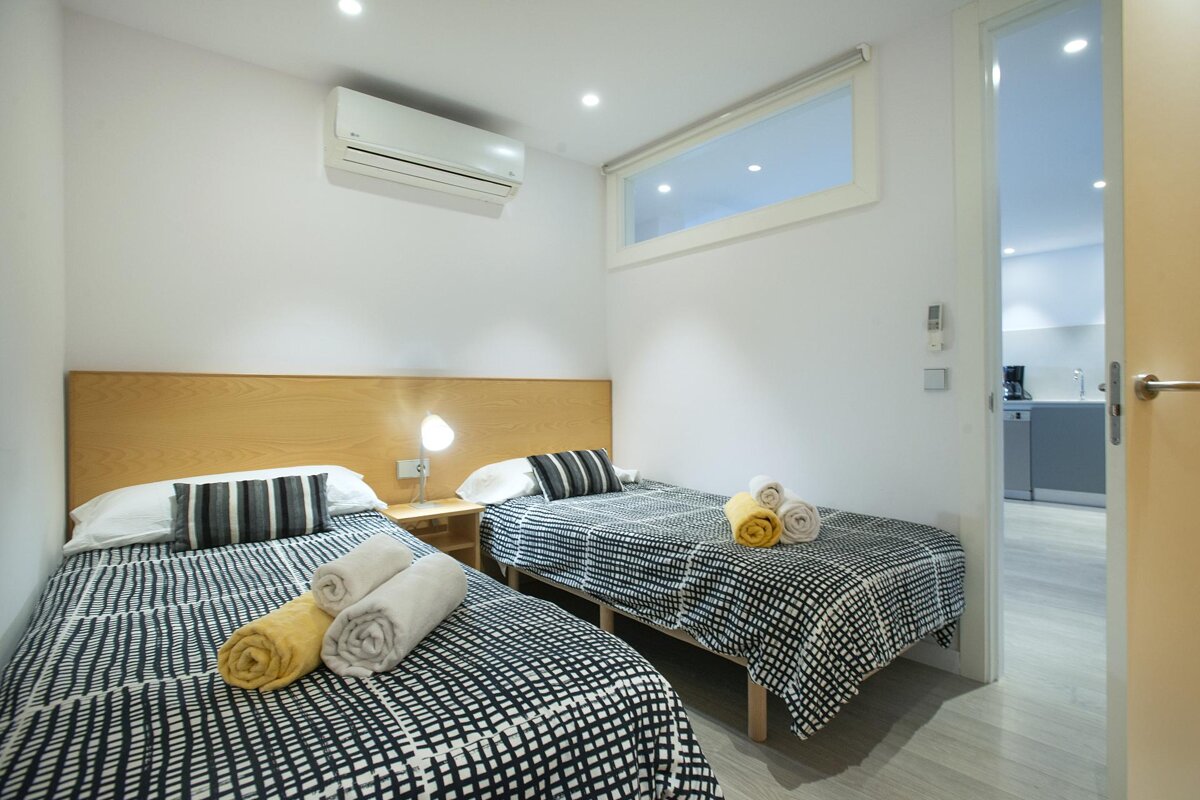 A bedroom with two twin beds and a window